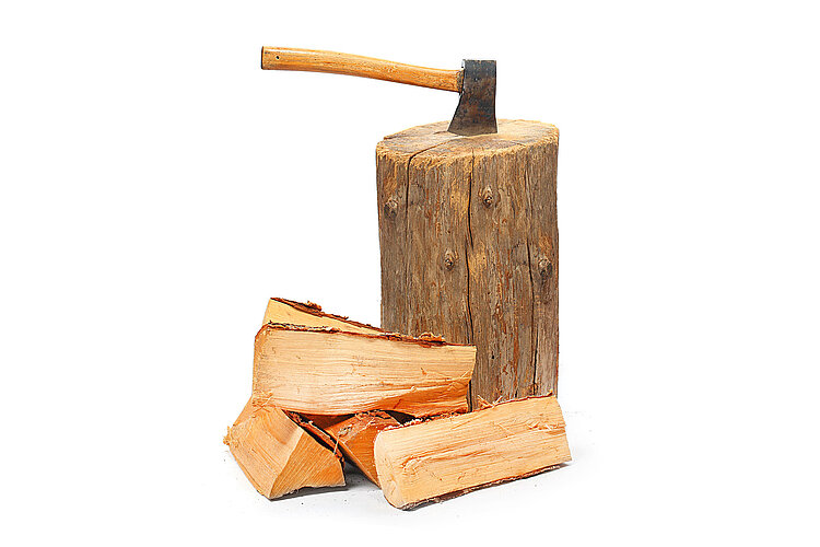 Holzhackstock mit eingeschlagener Axt und Holzscheiten von Brennholz Herbst.